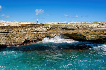 Devil's Bridge, parish of Saint Philip, in Antigua and Barbuda. General view, unrecognizable men for scale on the top. Copy space.