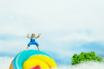 Miniature people toy figure photography. Playground island above clouds. A bald clown wearing...