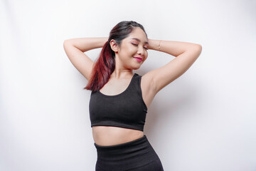 Naklejka premium Smiling sporty Asian woman wearing sportswear is relaxing after working out