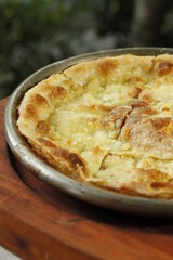 Closeup of thin crust flatbread stuffed with cheese