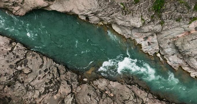 Mountain river. A rapid flow of clean water between rocks. Bubbling water, foam and splashes. Water flow in a mountain gorge. Slow motion 120 fps.