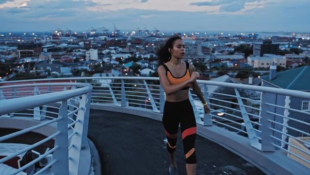 Runner, black woman and bridge in city with music streaming earphones at night in Cape Town, South Africa. Wellness, exercise and running girl with audio playlist app for fitness, training and focus.
