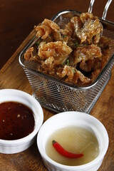 Chicharon bulaklak, finger food from the Philippines made from deep-fried pork ruffled fat, with vinegar and chili sauce