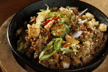 Sizzling pork sisig, a dish from the Philippines made from chopped pig ears and snout, with onions, peppers, pork cracklings and kalamansi