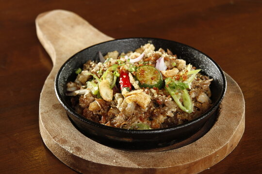 Sizzling pork sisig, a dish from the Philippines made from chopped pig ears and snout, with onions, peppers, pork cracklings and kalamansi
