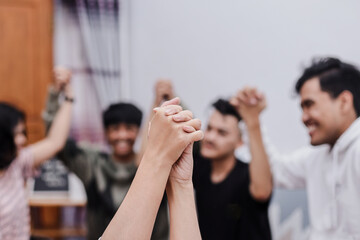 Symbolic picture showing that we are stronger together. Two people holding hand and raising in...