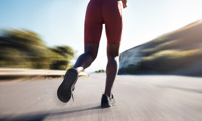 Motion blur, woman and legs running on road for exercise, marathon workout and sports training. Back view, closeup and runner athlete with fast energy, fitness health and performance power outdoors