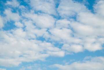 Natural background of blue sky, fluffy clouds, and cloudscape in the daytime.