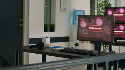 Multiple monitors displaying computer malfunction and security breach in empty programming office. Computers showing critical error message flashing on screen and system crash on desk.
