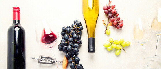 Flat-lay of red and white wine in glasses and corkscrews over grey concrete background, top view,...