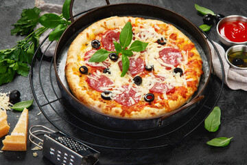 Freshly baked pepperoni pizza on dark background.