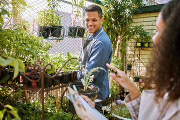 Gardening, flowers and plants with a couple checking in the garden together for a botany hobby at...