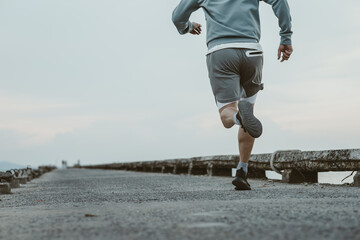 healthy lifestyle young fitness man running at seaside old bridge. Outdoor workout,  Healthy...