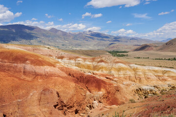 Fototapeta na wymiar Beautiful multicolored mountains against a blue sky with clouds in variable weather. Mars 1.
