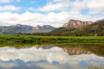 Steep cliffs of the Capertee canyon reflecting in water
