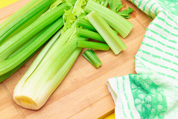 Fresh Celery Stem and Chopped Celery Sticks on Wooden Cutting Board. Vegan and Vegetarian Culture. Raw Food. Healthy Diet with Negative Calorie Content. Slimming Food