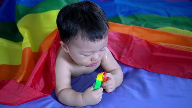 Baby boy chew sensory toy under LBGT flag