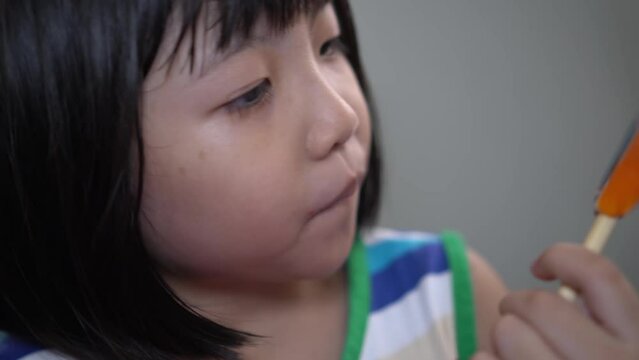 Chinese girl taste and lick the sweet lollipop.