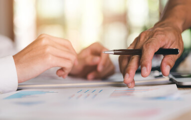 Businessman pointing business statistic chart report, to analyze and improve corporate strategy, manage financial and marketing documents, update annual budget accounts, company growth data..