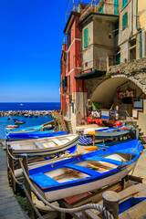 Fototapeta na wymiar Mediterranean Sea, colorful boats and houses, Riomaggiore in Cinque Terre, Italy