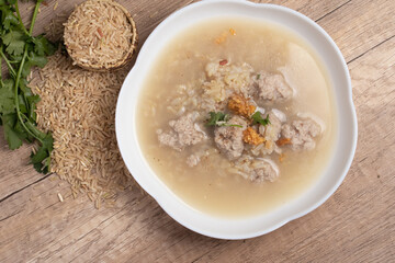 Jasmine brown rice porridge with pork on wooden background.Healthy food copy space
