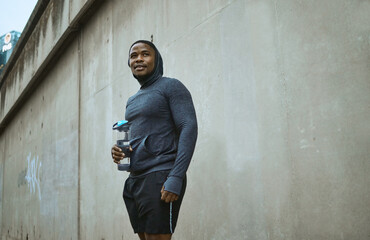 Obraz premium Fitness, water bottle and black man in city after training, exercise and running. Sports, break and male runner with refreshing liquid after jog, exercising or workout in town or street in winter.