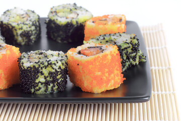 Sushi Set - different types of Maki sushi and chopsticks on a b