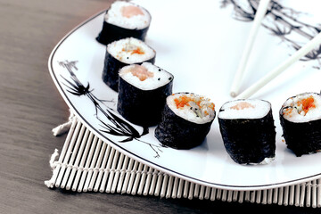 close-up of sushi and chopsticks on a white plate