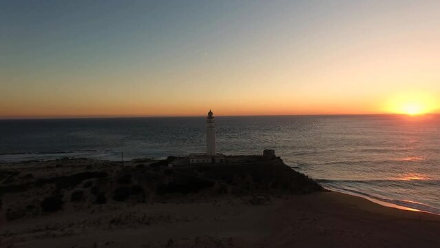 View of the setting sun at horizon in the Ocean late evening drone view around the Trafalgar Lighthouse in Cadiz Spain
