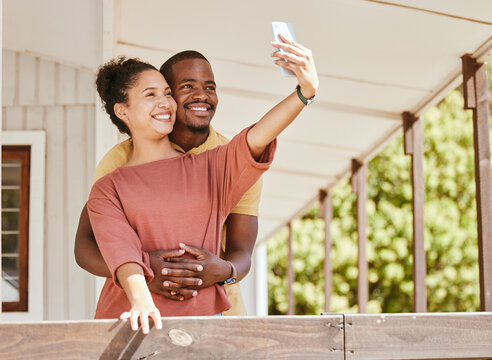 Love, phone selfie and black couple in home by balcony, bonding and having fun. Romance, hug and man and woman taking pictures on mobile smartphone for happy memory, social media or profile picture.
