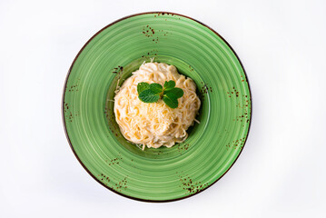 pasta sprinkled with cheese, mint on a white background