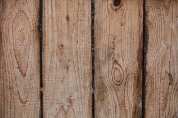 An old wooden fence made of brown dry boards. Vertical boards - vintage background texture.