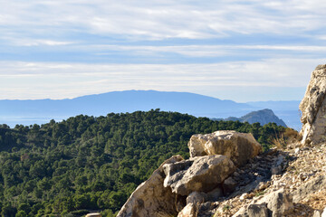 Panoramic mountain scene in Spain with rock cliff and pine forest