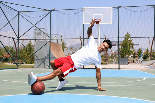 Man practicing dance moves with basketball at sports court
