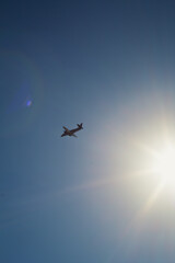 Airplane flying across blue sky landscape photo. Beautiful nature scenery photography with atmosphere on background. Idyllic scene. High quality picture for wallpaper, travel blog, magazine, article