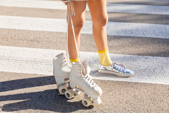 Girl with roller skates standing on zebra crossing