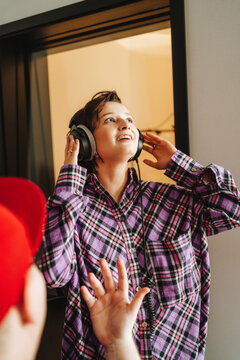 Singer wearing headphones in front of colleague at studio