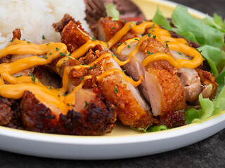 Fried chicken over rice and spicy sauce.