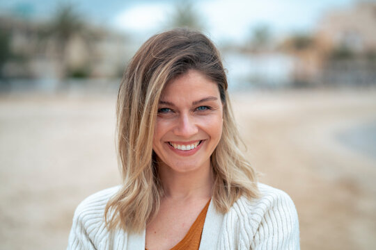Smiling beautiful young blond woman at beach enjoying weekend