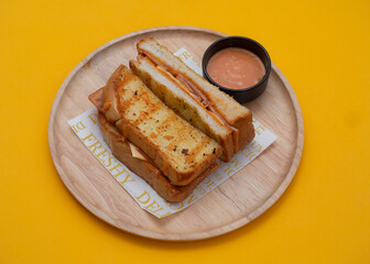 Bacon egg cheese sandwich toast with wooden plate on yellow background.