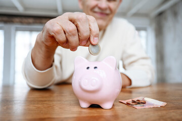 Man putting coin into piggy bank at home