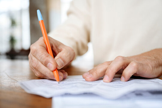 Man Writing On Bills With Pen