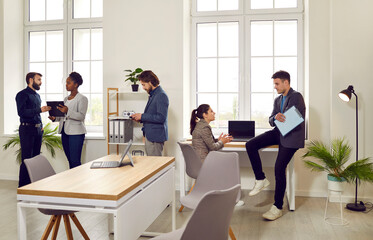Daily life in the office. Diverse corporate employees working in the company office. Different young multiracial people meet in their workplace, discuss business projects and do other things