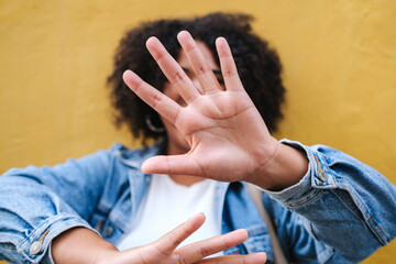 Woman showing stop gesture in front of wall
