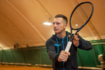 male tennis player on the court looks happy doing his hobby.
