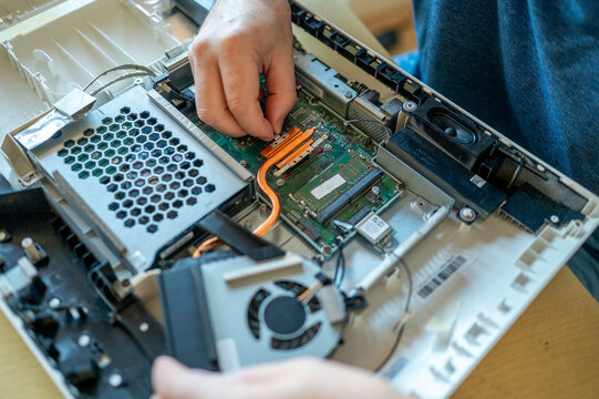 Hands of man repairing computer on table