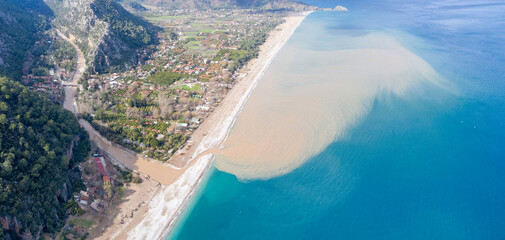 Bird’s eye view of muddy waters of river flowing into the Mediterranean sea on sunny winter day....