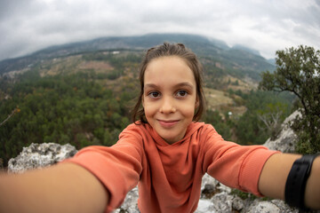 cute child takes a selfie on the phone while traveling.