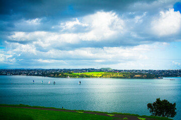 Sailing boats racing across calm waters of Auckland Harbour on a beautiful winter day. North...