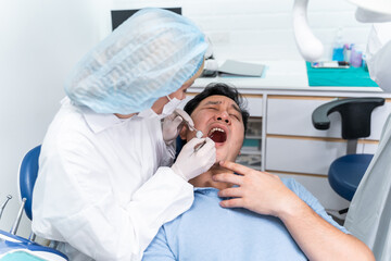 Caucasian dentist examine tooth for young man patient at dental clinic. 